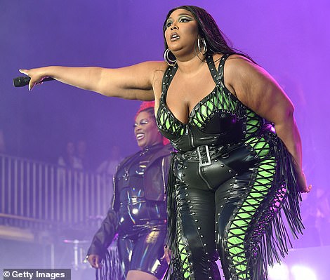 Sєxy: The 35-year-old rapper modeled a figure-hugging bodysuit featuring black leather fringe and lace-up details over neon green latex as she took the stage to perform her many award-winning hits