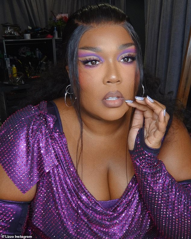 Ready for the stage: Lizzo wore a sequin-covered purple dress that was paired with matching sleeves as while posing for the pH๏τos