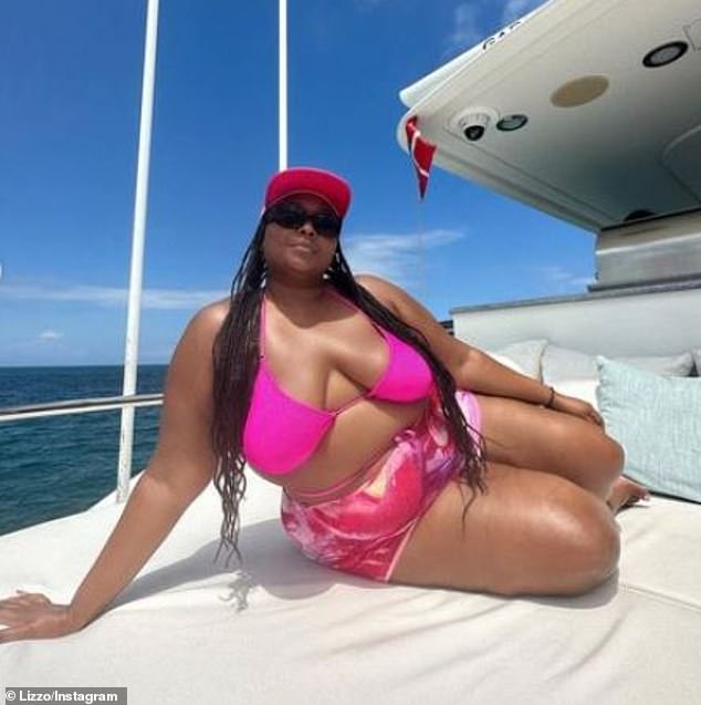 Flaunting: Lizzo, 34, posed  on a boat while vacationing in the Bahamas, donning a bright pink ʙικιɴι and print shorts as she luxuriated on a yacht