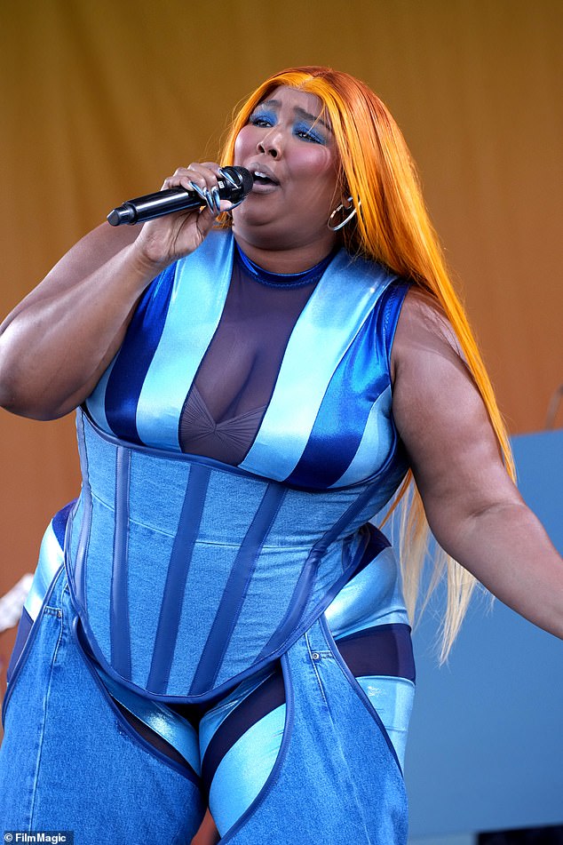 Bold look: While giving a show-stopping performance, the singer and rapper put on a stylish display in a striped jumpsuit with various Sєxy mesh cutouts underneath a denim corset and the matching chaps