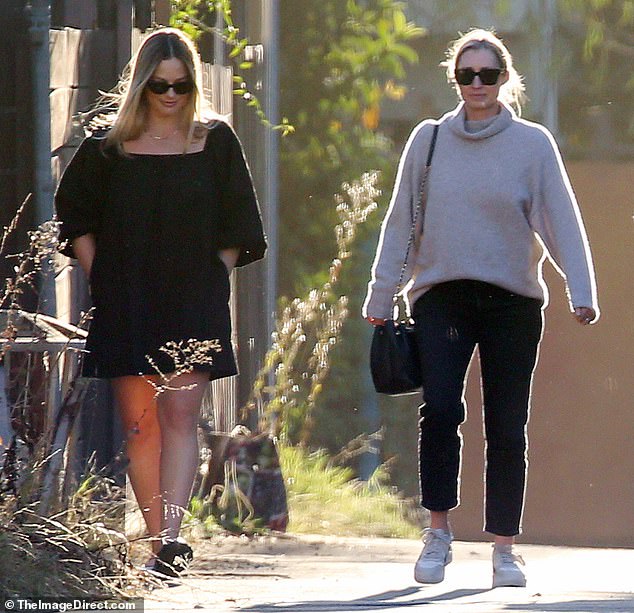 Margot Robbie looked relaxed as she enjoyed a walk with a friend in Los Angeles on Thursday. The actress, 34, who welcomed her first child in October,  was seen strolling in a black mini dress with elbow length puffed sleeves and black sandals